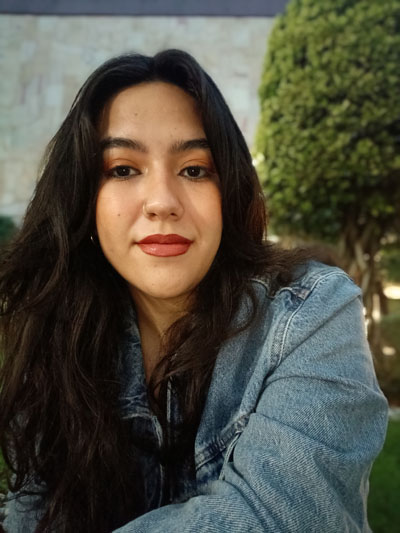 Una mujer con cabello largo y negro que lleva una chaqueta vaquera azul.